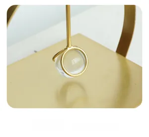 Detail of a minimalist gold metal iron frame holding a crystal ball centerpiece