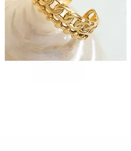 Detailed macro shot of a double-layer golden ring with curb chain and bead texture