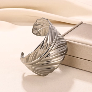 Detailed close-up of textured wide open bangle with geometric feather pattern and matte finish