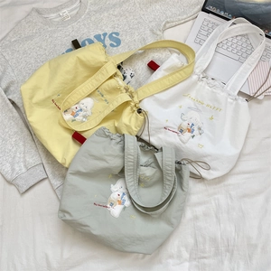 Three canvas tote bags in yellow, beige and green colors with cute dog embroidery