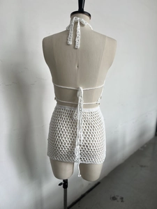 Back view of white handmade crochet halter top and hollow mini skirt set on a mannequin