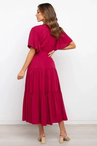 Detalle del vestido fucsia con mangas con volantes y falda de capas vista de la espalda