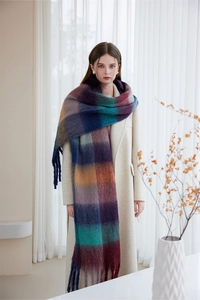 Close-up of thick plaid scarf with soft fringe tassels worn over shoulders