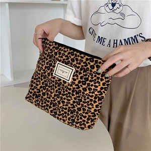 Close-up of leopard print canvas makeup bag with zipper and PLEASANT TIME label