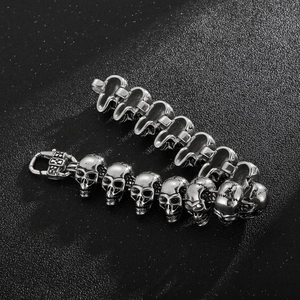 Close-up of vintage steel skull bracelet links with detailed carved texture and clasp