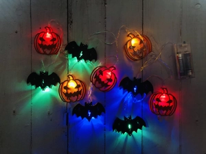 Macro detail of LED Halloween string lights with glowing pumpkin and bat shapes