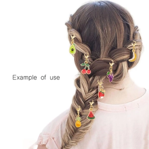 Detail showing fruit-themed metal charms used as colorful hair accessory decorations