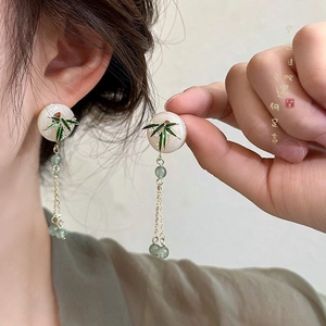 Detail of vintage flower heart earrings with green bamboo leaves and dangling beads