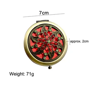 Vintage bronze compact mirror with ornate floral crystal inlay and portable folding design