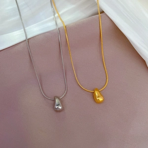 Titanium steel water drop necklace in gold and silver finish on silk fabric