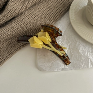 Detail of tortoise shell acetate hair claw clip with three yellow calla lily flowers
