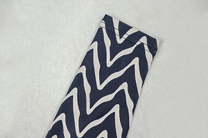 Gros plan du poignet à motif ondulé bleu marine et crème avec couture double précise