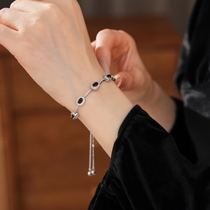 Detail eines verstellbaren Silberarmbands mit ovalen schwarzen Zirkonia am Handgelenk