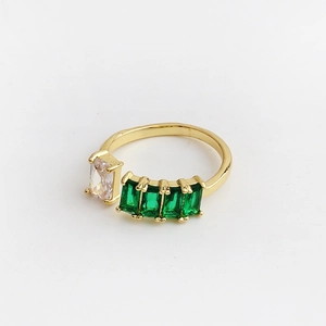 Detail of gold open ring featuring one white and four green rectangular emerald-cut zircons