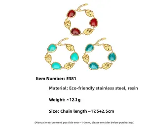 Detailed view of irregular molten gold stainless steel bracelets with red and turquoise resin