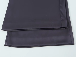 Détail du tissu satiné gris foncé montrant les coutures de l'ourlet et la texture