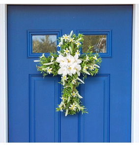 Detail of Easter door wreath with white lilies and green leaves on a blue door