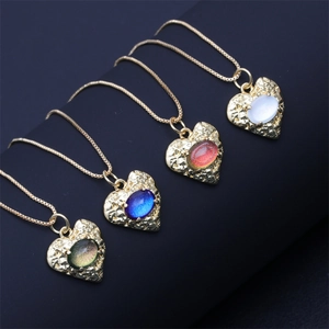 Detail view of heart-shaped gold pendants with hammered texture and colorful gemstones