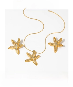Macro detail of gold PVD plated starfish jewelry set with sparkling micro-inlaid crystals