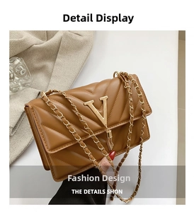 Nahaufnahme braune Stepptasche mit goldenem V-Logo und dekorativem Fransenanhänger