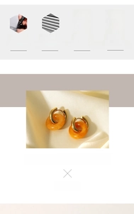 Detailed macro view of 18K gold plated hoop earrings with orange natural stone pendants