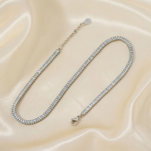 Elegant silver necklace with rectangular cubic zirconia on a beige silk background