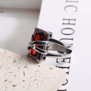 Macro view of a silver stainless steel ring with a rectangular red ruby on a stone base