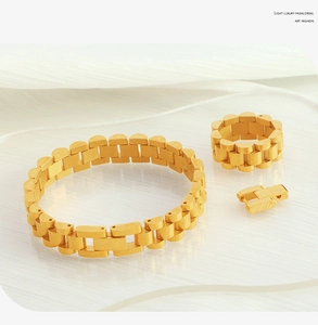 Detail of gold watchband style bracelet and ring with brushed matte finish texture