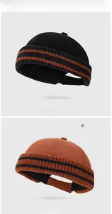 Details von gerippten Docker-Mützen in Schwarz und Orange mit dicker Strickkante