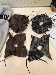 Detail of plaid scrunchies with long black ribbons in brown and grey tones