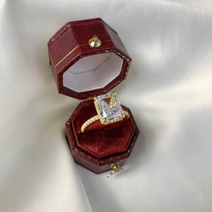 Detailed close-up of a square ice flower cut zircon ring in a red velvet jewelry gift box