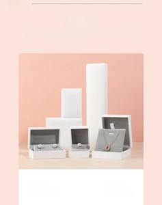Detailed set of white jewelry boxes with gray velvet lining on a pink background