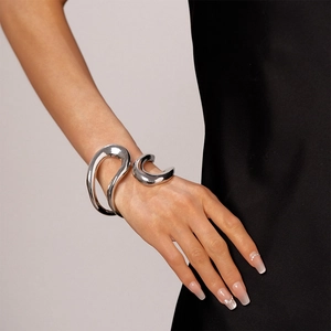Silver abstract geometric open bangle shown on a wrist with sleek metallic finish