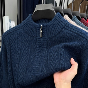 Detail of navy cable knit sweater showing thick texture and metal half-zipper collar