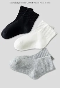Detailed knit texture of white, black, and grey mid-calf cotton socks with ribbed cuffs