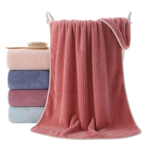 Coral fleece bath towels with honeycomb texture in various colors on white basket