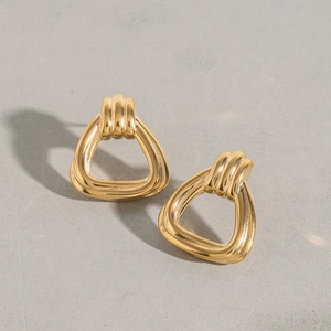 Macro view of geometric triangle titanium steel earrings with a polished gold finish