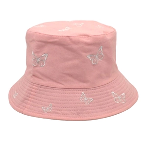 Détail de la broderie de papillon blanc sur un chapeau bob en toile de coton rose