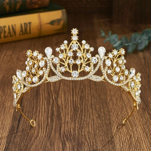 Baroque gold crown with water drop diamonds for women on a rustic wooden surface