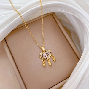 Macro view of gold titanium steel ruyi lock pendant with sparkling pavé crystals