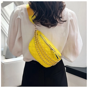 Detail of yellow quilted fanny pack featuring gold chains and a wide adjustable strap