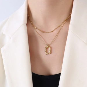 Double-layer gold necklace with irregular rectangle pendant on white blazer model