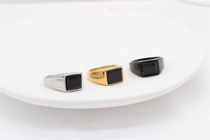 Detailed view of square black gemstone signet rings in silver, gold and black finishes