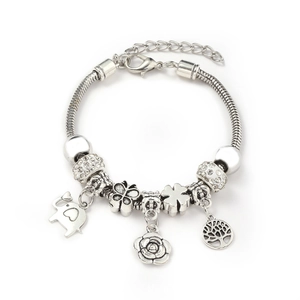 Silver charm bracelet with elephant and tree of life pendants on white background