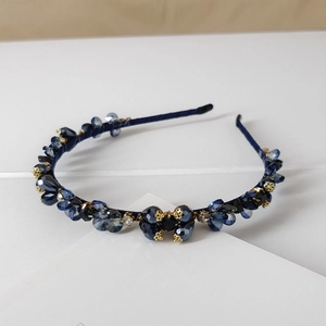 Close-up of handmade deep blue crystal bead headband with elegant gold floral accents
