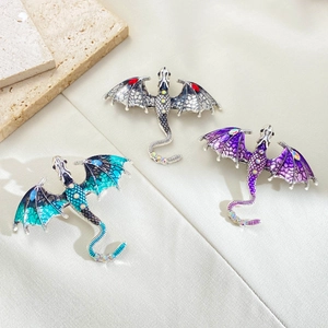 Detailed close-up of retro dragon brooches with enamel finish and small crystals