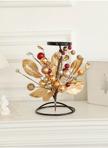 Detail of iron Christmas candle holder with golden leaves and colorful beads on mantel