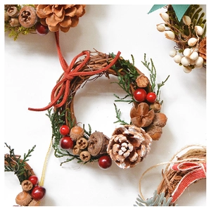 Close-up of handmade Christmas wreath with pine cones berries and natural greenery