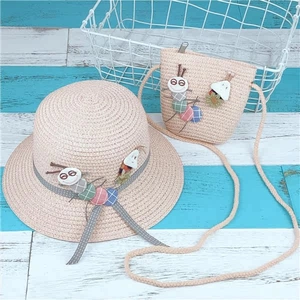 Detailed close-up of kids straw hat and matching crossbody bag with cute caterpillar appliques