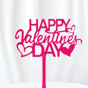 Close-up of pink acrylic Happy Valentine's Day cake topper with a heart design